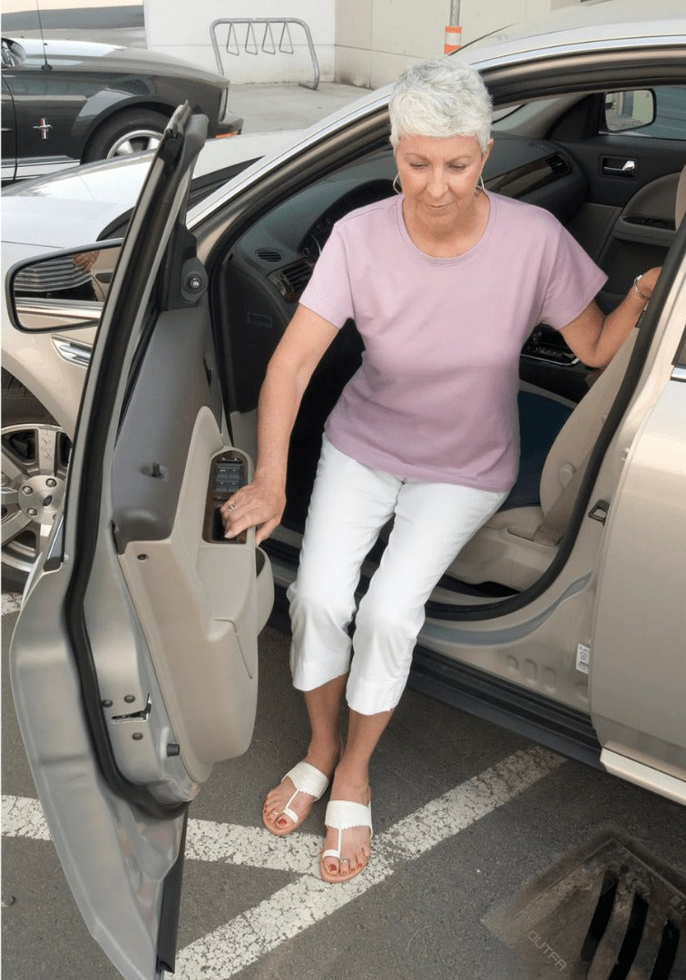 Mujer mayor bajando del coche