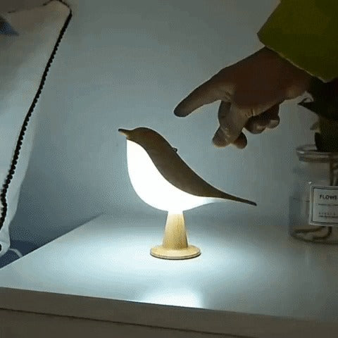 Finger touching the bird lamp